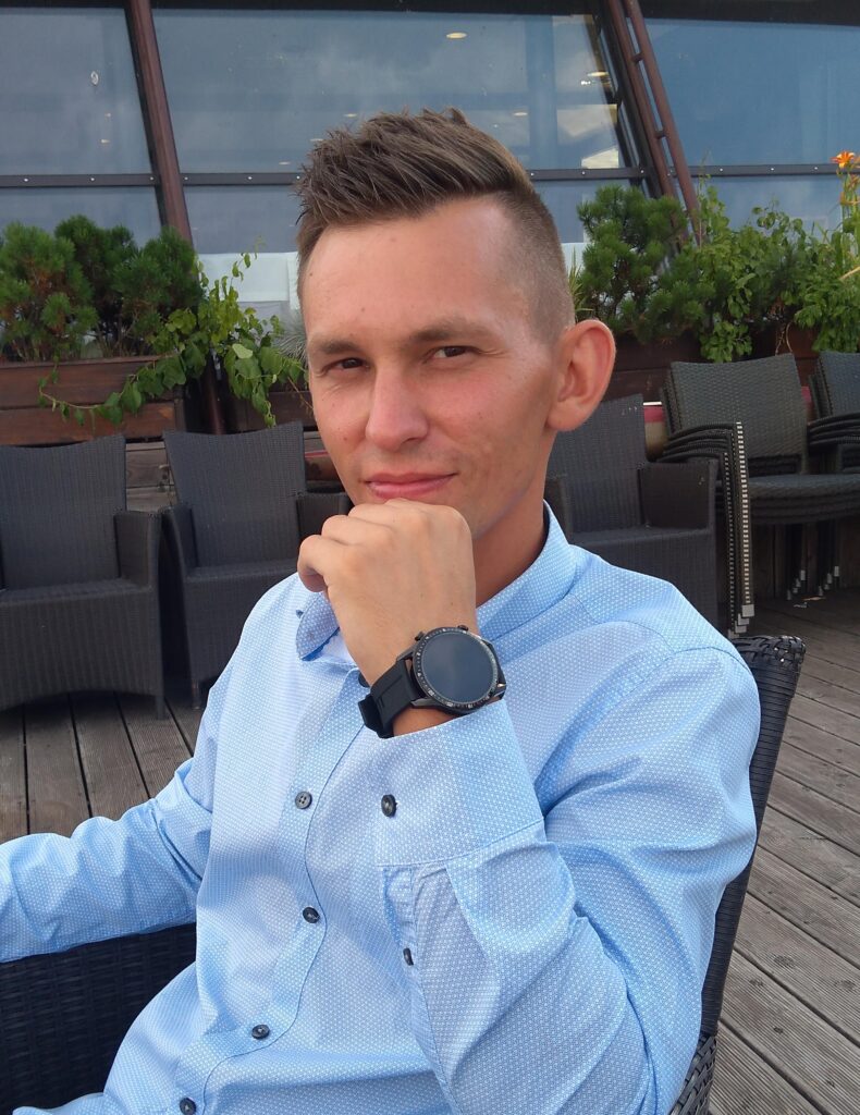 Mężczyzna w niebieskiej koszuli na tarasie.